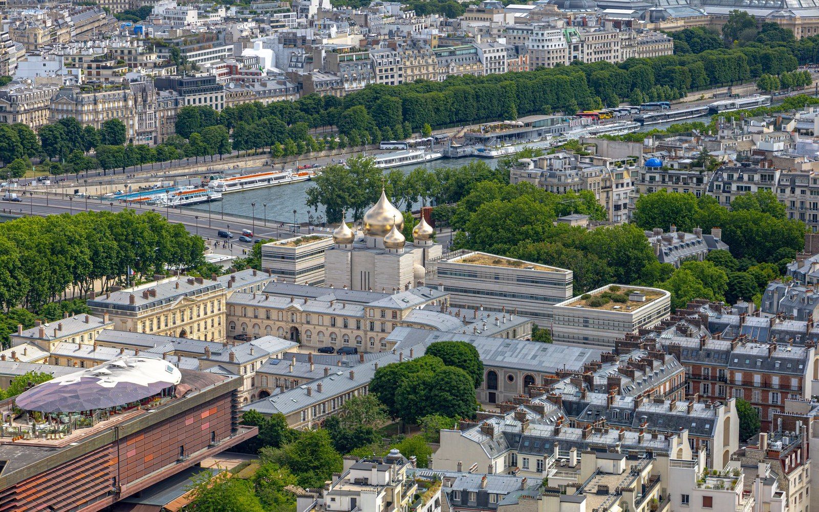 Golden onion domes of a Russian Orthodox cathedral rise above rooftops near the Seine